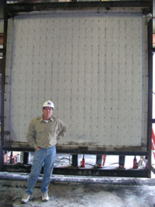BuildBlock CEO Mike Garrett stands in the front of the post-test wall which is loaded down with 12,000 lbs per lineal foot of pressure.