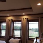 Master bedroom with large windows and raised ceiling